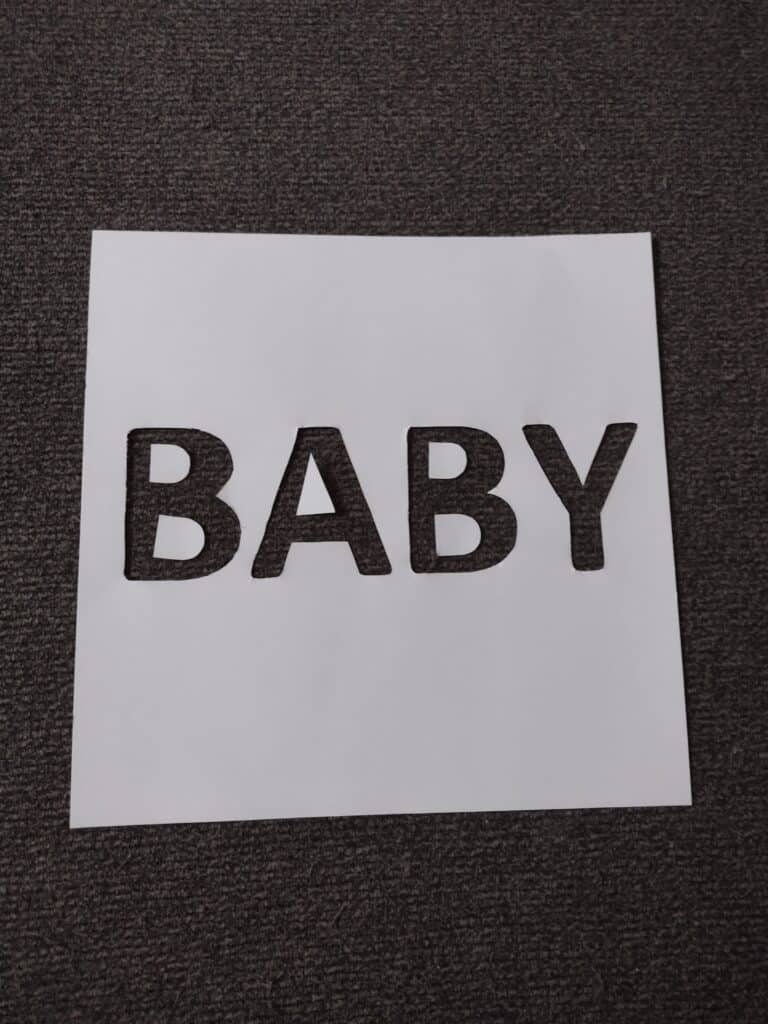 Picture of paper with the word "baby" cut out
