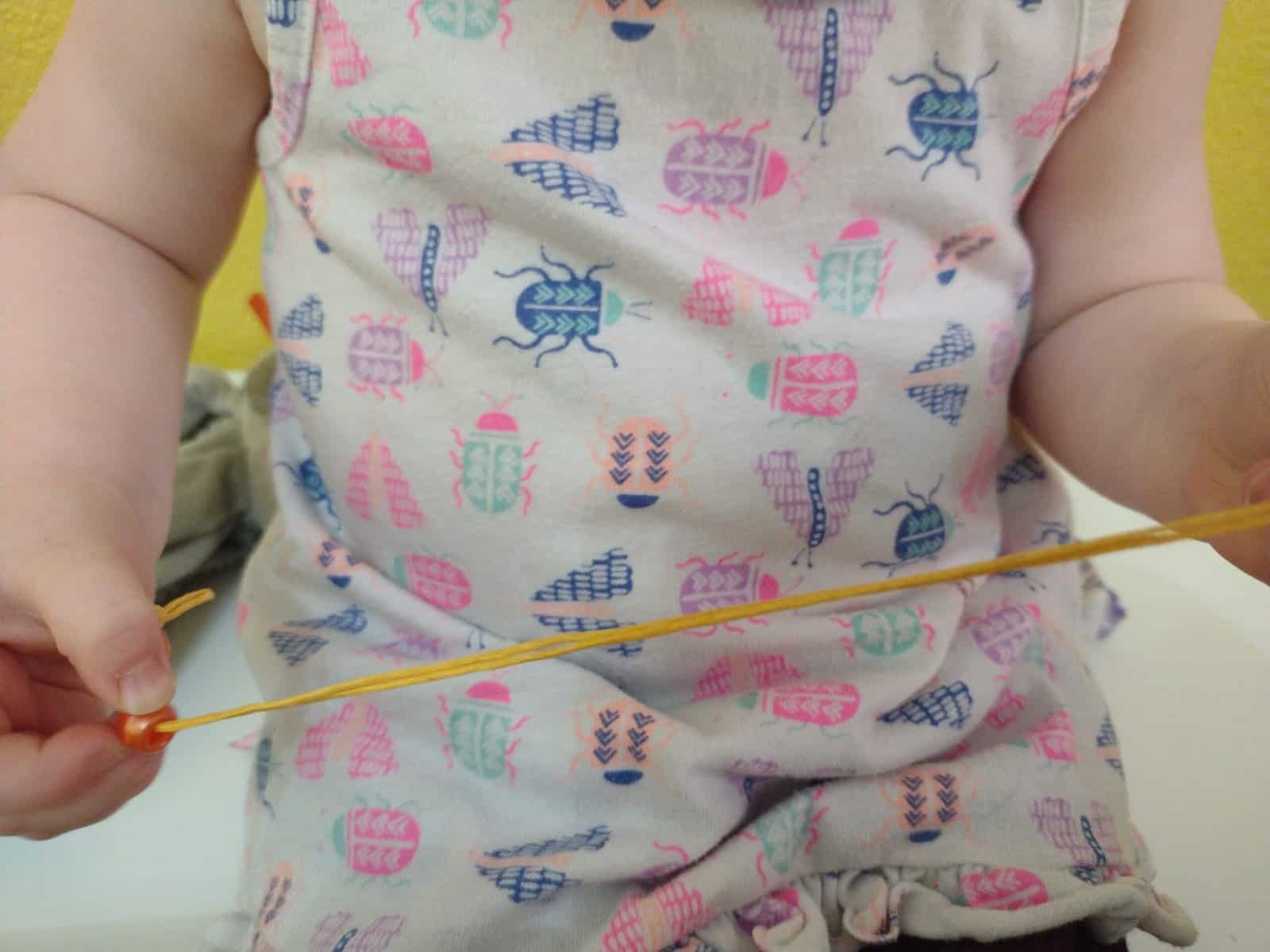 Picture of toddler string beads onto string