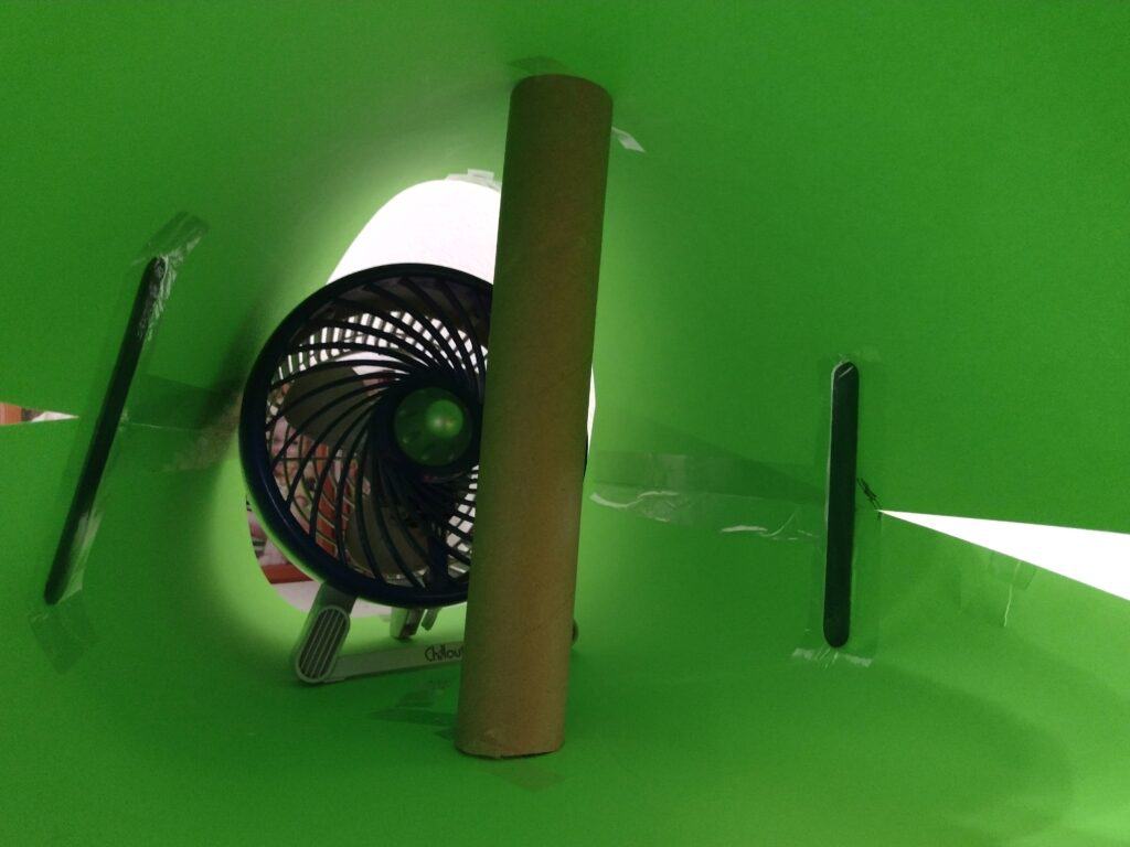 Picture of popsicle sticks and a cardboard tube holding up a poster board tube