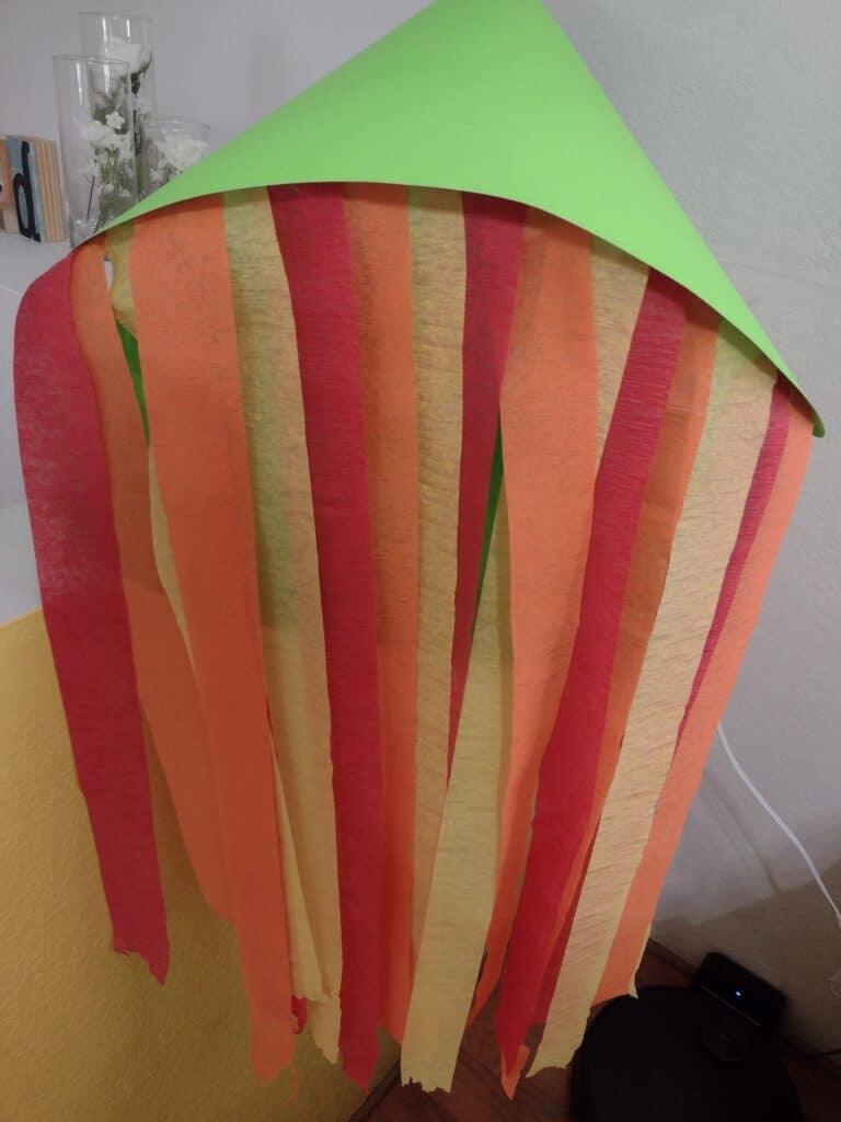 Picture of red, orange, and yellow streamers taped to a green poster board tube