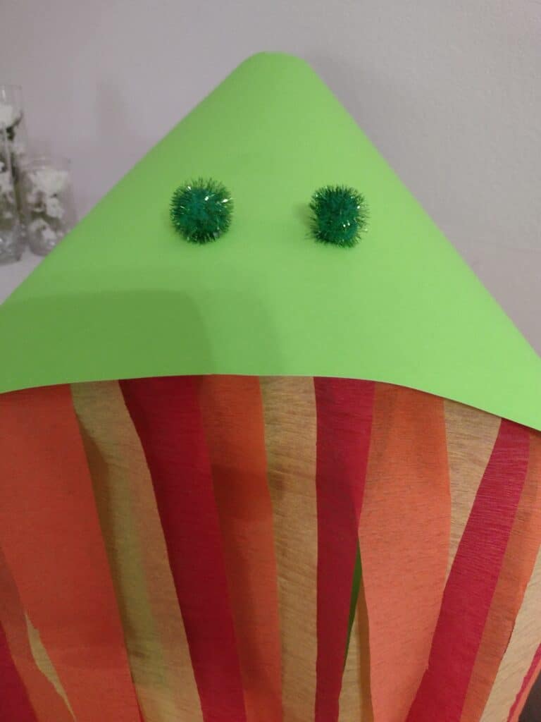 Picture of pom pom nostrils glued on to a poster board dragon head