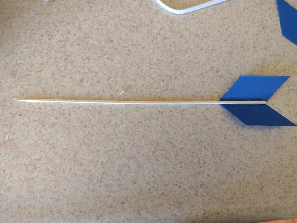 Picture of wooden skewer with arrow fletching shaped cardstock glued to the end