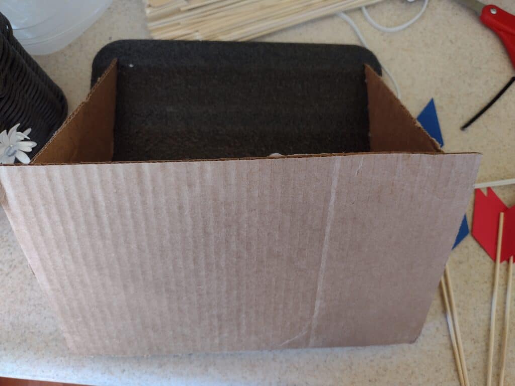 Picture of rectangle piece of cardboard glued to two triangle support pieces of cardboard