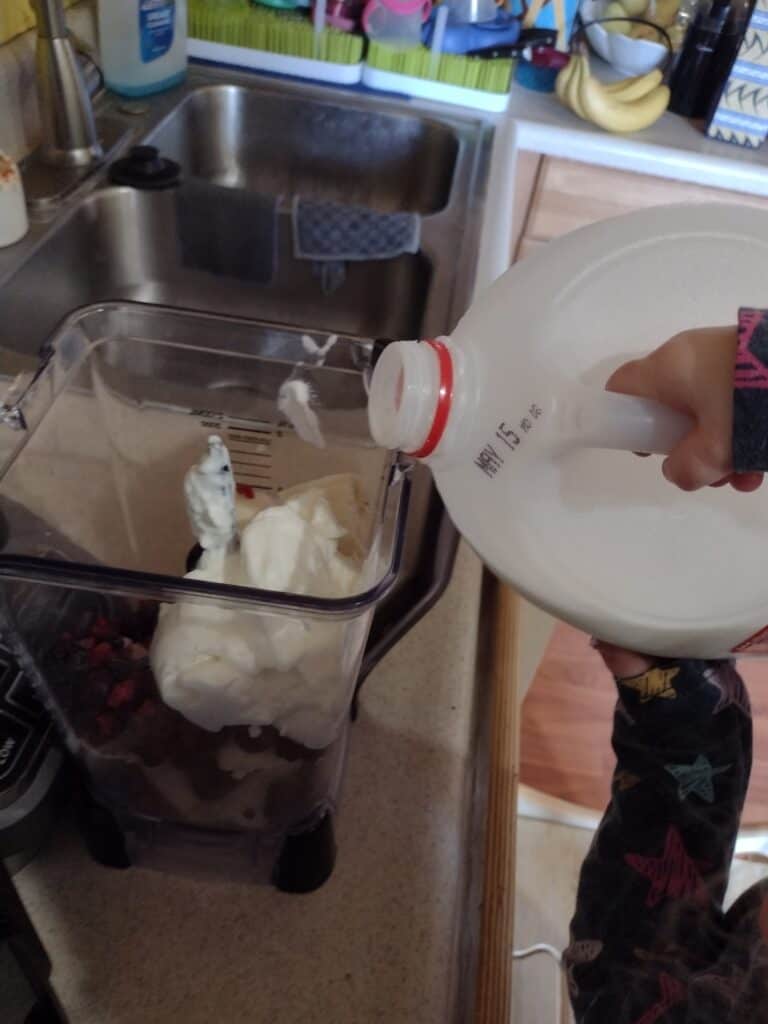Picture of a preschooler pouring milk into a blender