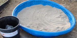 Picture of kid wading pool filled with sand and seashells for a sandbox treasure hunt