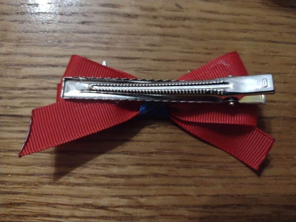Picture of an alligator clip glued to the back of a red hairbow