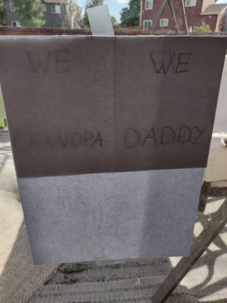 Picture of a piece of printed taped on top of a piece of cardstock that says we Grandpa and we Daddy