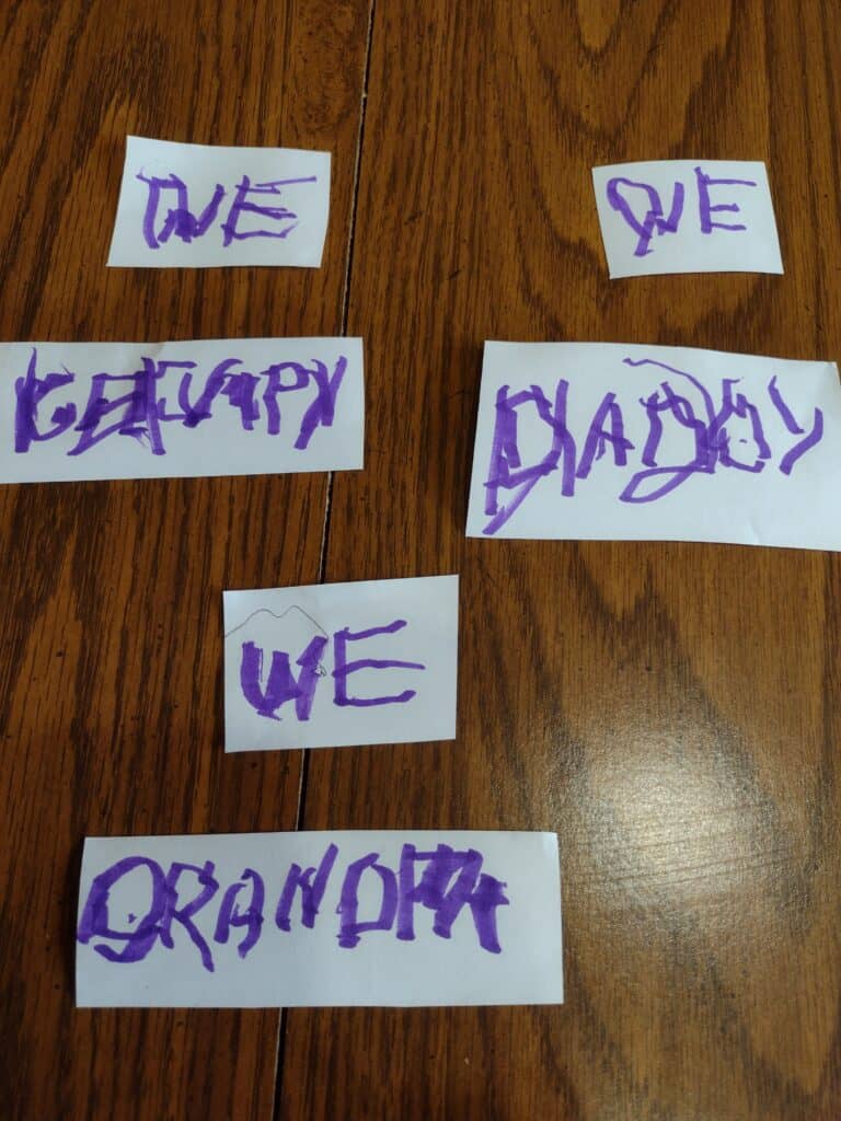 Picture of the words We, Grumpy, Daddy, and Grandpa written by a preschooler cut out in strips