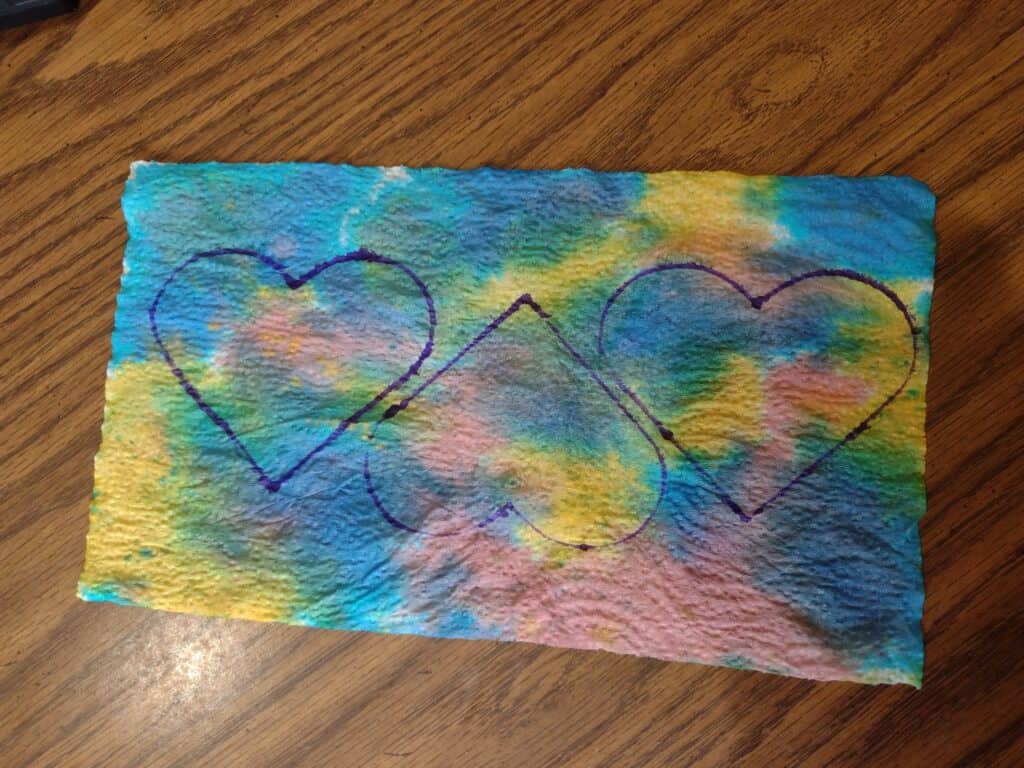 Picture of three hearts traced on a tie dye paper towel