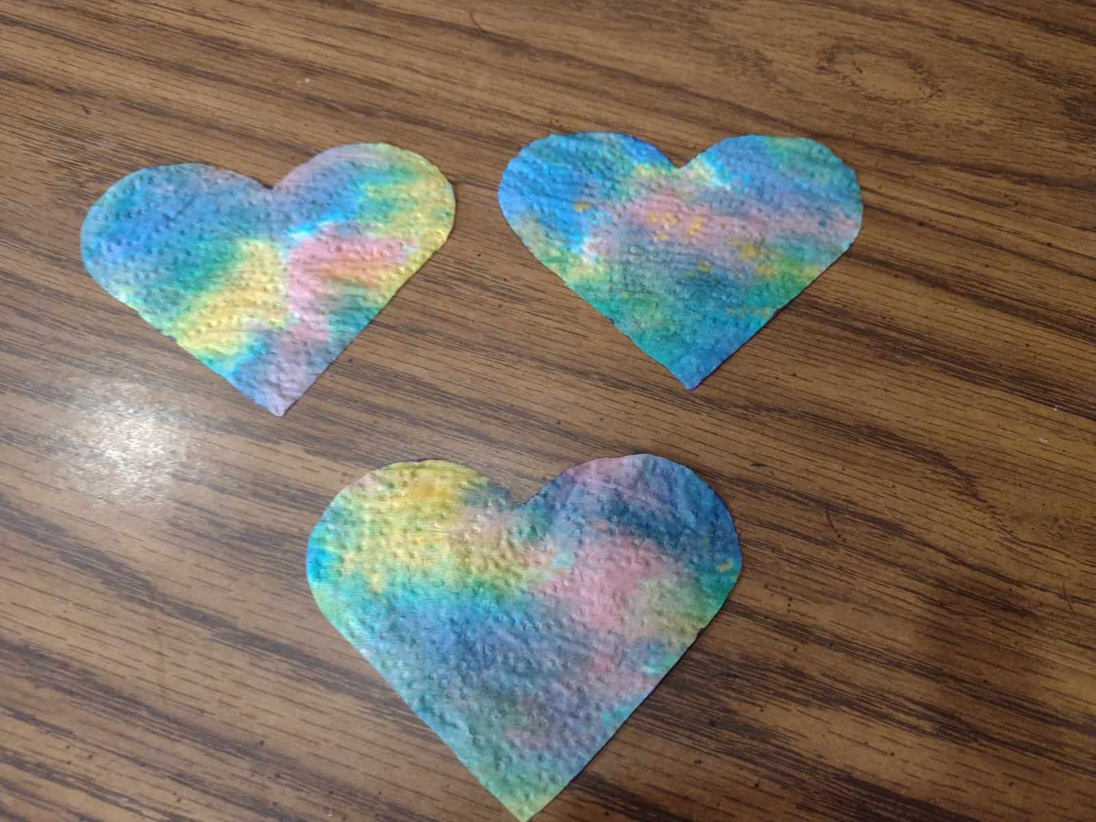 Picture of three hearts cut out from a tie dye paper towel
