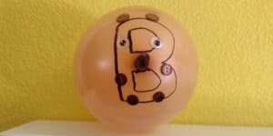 Picture of B is for bear craft sitting on a shelf. A large B is drawn on a balloon with button ears, eyes, nose, and paws glued on