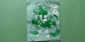 Picture of an A is for alligator craft that was painted with green and white acrylic paint using apples