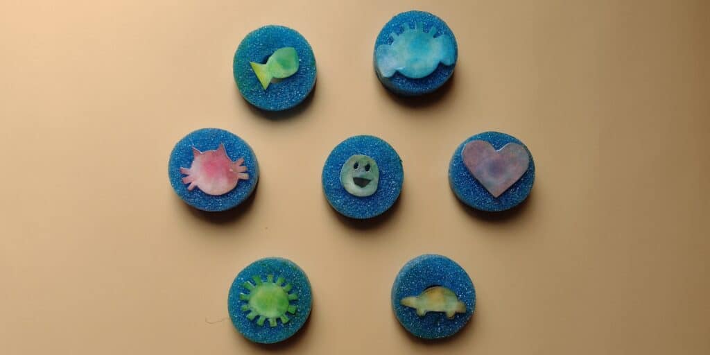 Picture of handmade stamps including a fish, elephant lovey, cat, smiley face, heart, sun, and car.