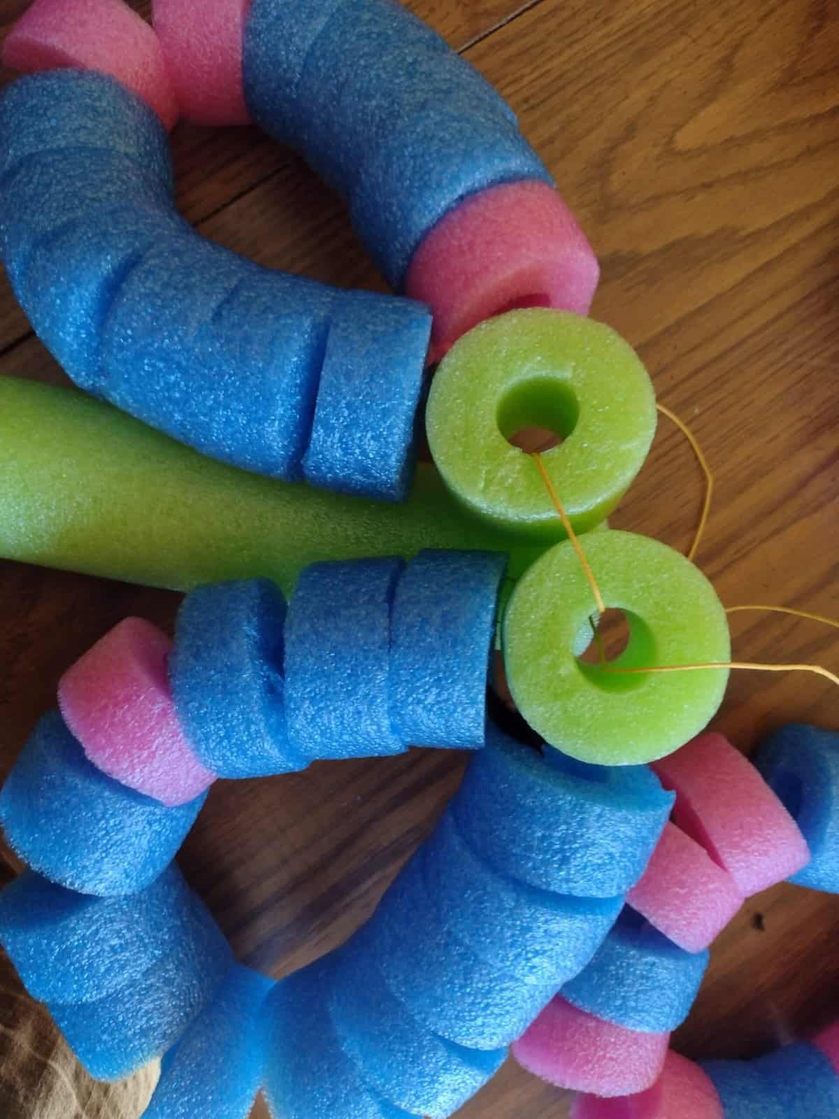 Picture of two pool noodle flower petals tied to a pool noodle stem