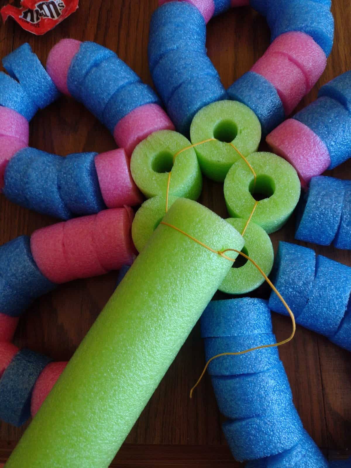 Picture of all five petals of a pool noodle craft threaded together tightly and tied to a pool noodle stem on the back