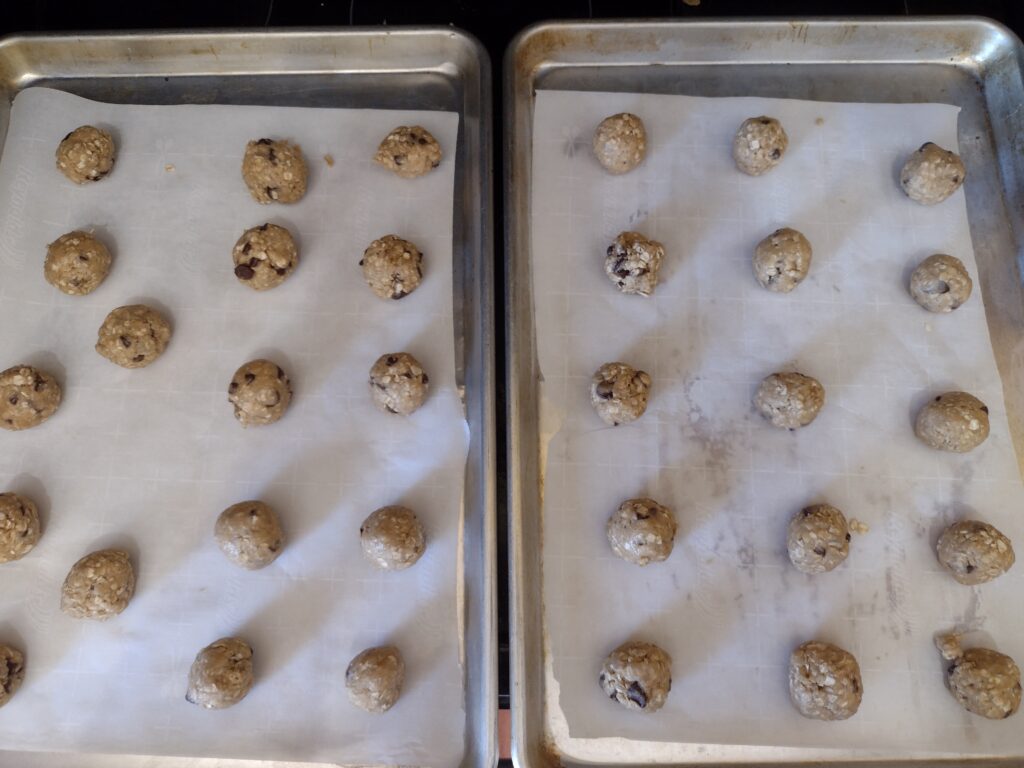Picture of two cookie sheets full of small oatmeal cookie balls