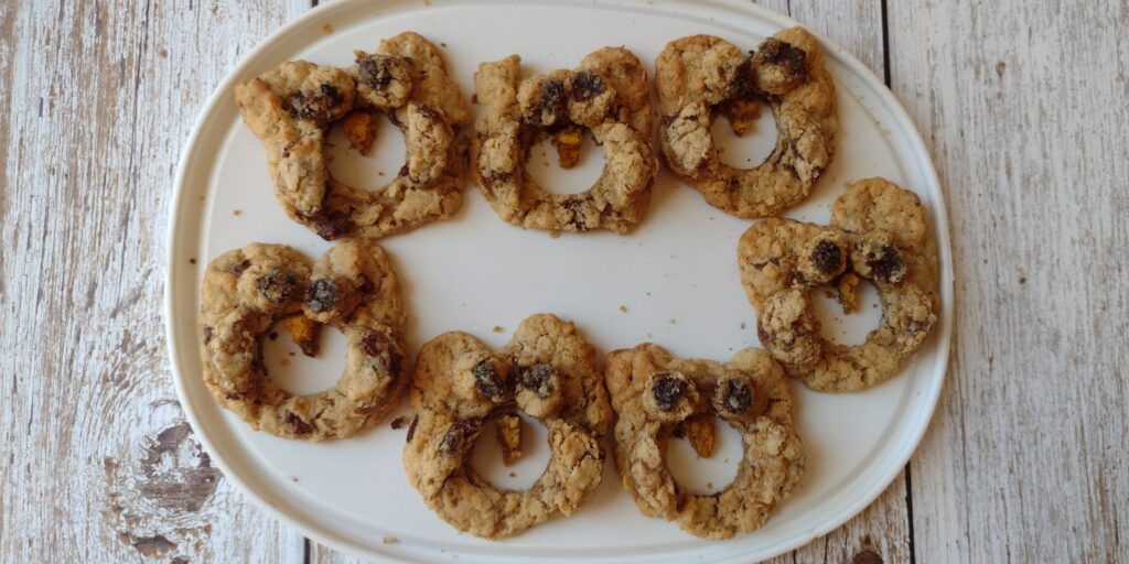 Picture of an O is for owl craft. Seven oatmeal cookies that look like O shaped owls are sitting on a white tray