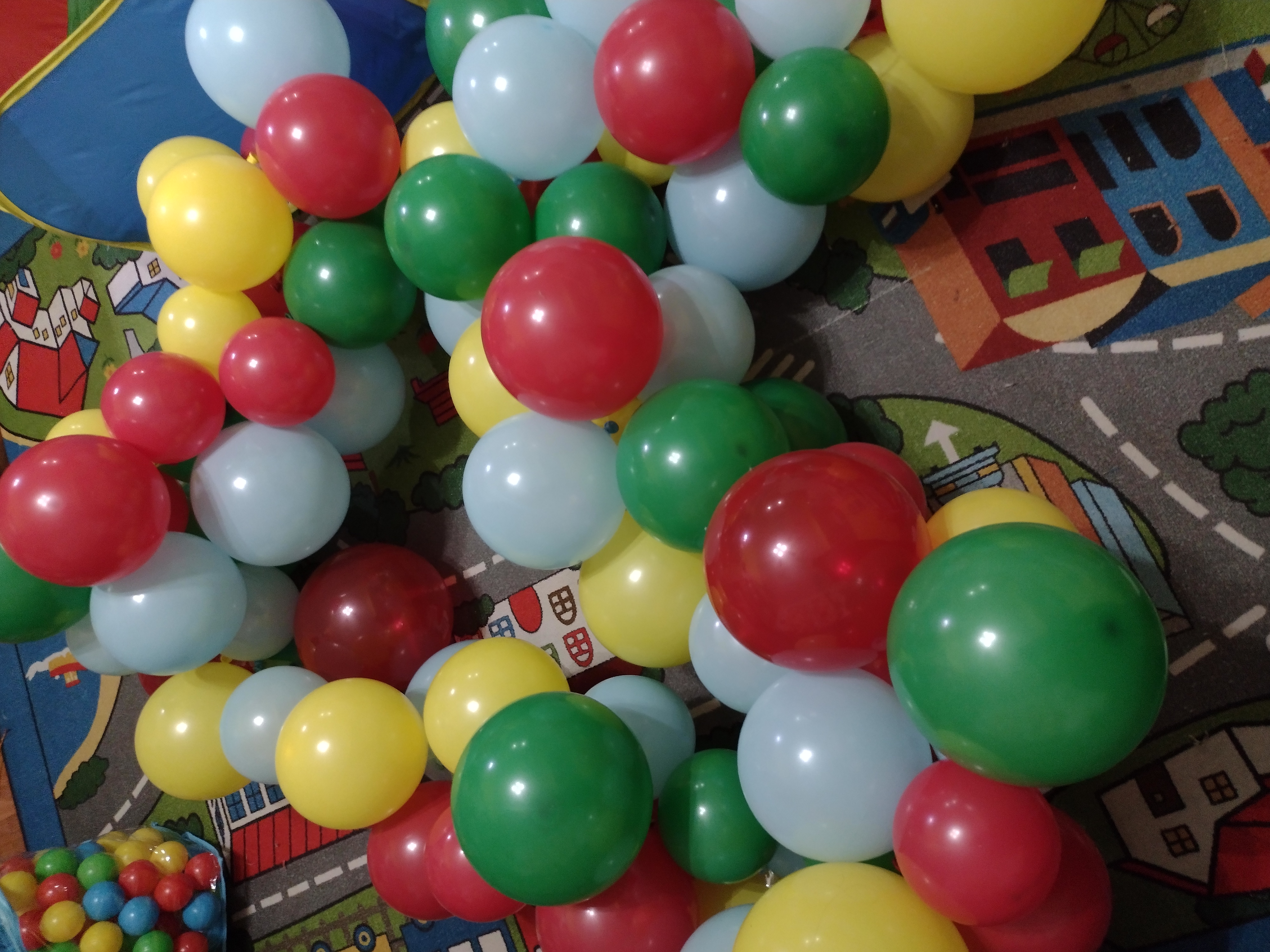 Picture of a pile of balloons attached to balloon tape sitting on the ground