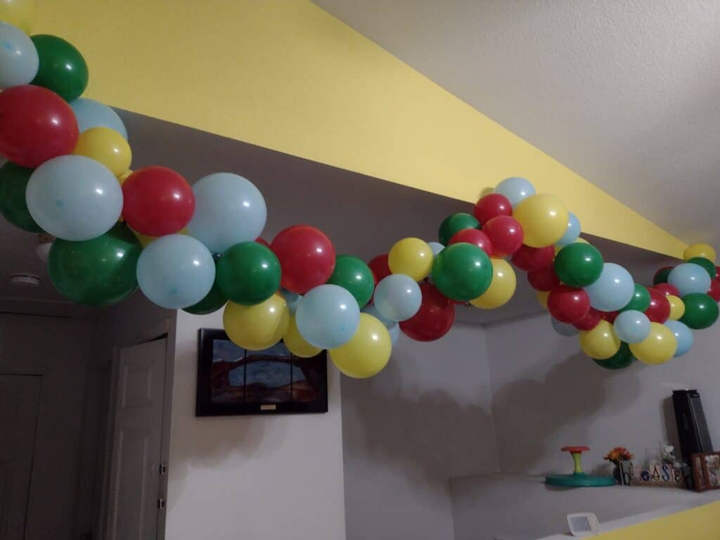 Picture from the side of a balloon garland made from red, green, yellow, and blue balloons