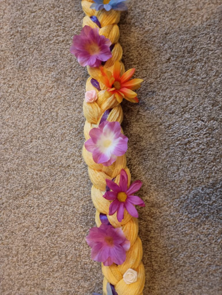 Picture of fake flowers glued to Rapunzel hair made from yarn